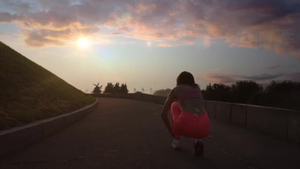 Ung kvinna kör med sportwatch molnigt på morgonen vid solnedgången — Stockvideo
