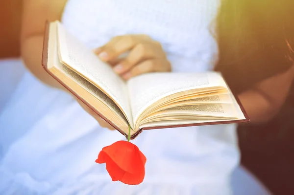 Mädchen in einem Mohnfeld mit einem Buch — Stockfoto