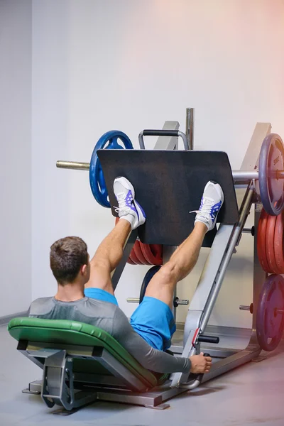 Fitness man shakes his legs — Stock Photo, Image