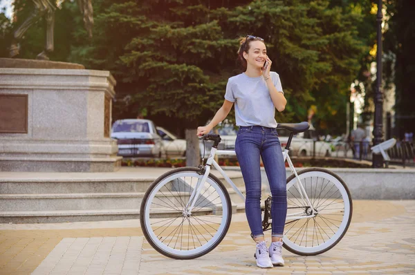 Fille avec vélo parler au téléphone — Photo