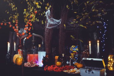 Cadılar Bayramı 'nın cam şişeleri ve mumları, lavanta ve siyah arka planda kırmızı biber. Falcılık ve simya masası. Mistik bir ortam. Kehanet. Büyücülük. İç..