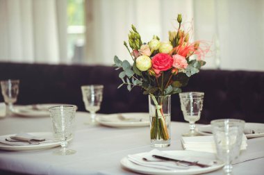 Beyaz bir masanın üzerinde pembe ve beyaz vazoların içinde çiçek aranjmanı, kopyalama alanı. Düğün süslemeleri, tatil konsepti