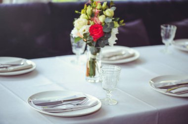 Beyaz bir masanın üzerinde pembe ve beyaz vazoların içinde çiçek aranjmanı, kopyalama alanı. Düğün süslemeleri, tatil konsepti