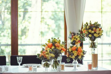 Beyaz bir masanın üzerinde pembe ve beyaz vazoların içinde çiçek aranjmanı, kopyalama alanı. Düğün süslemeleri, tatil konsepti