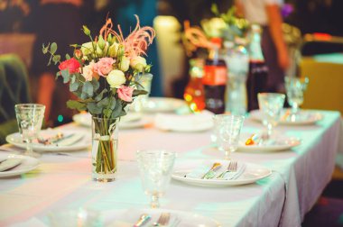 Beyaz bir masanın üzerinde pembe ve beyaz vazoların içinde çiçek aranjmanı, kopyalama alanı. Düğün süslemeleri, tatil konsepti