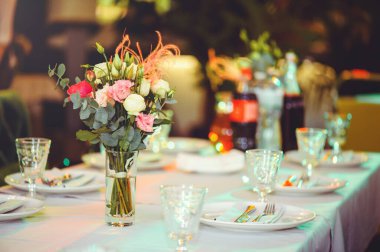 Beyaz bir masanın üzerinde pembe ve beyaz vazoların içinde çiçek aranjmanı, kopyalama alanı. Düğün süslemeleri, tatil konsepti