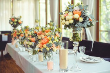 Beyaz bir masanın üzerinde pembe ve beyaz vazoların içinde çiçek aranjmanı, kopyalama alanı. Düğün süslemeleri, tatil konsepti