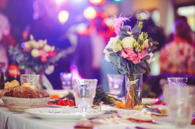 Beyaz bir masanın üzerinde pembe ve beyaz vazoların içinde çiçek aranjmanı, kopyalama alanı. Düğün süslemeleri, tatil konsepti