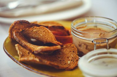 Taze ev yapımı tavuk ciğeri cam kasede ya da kalıpta ezilmiş ve masada bitkisel ve sarımsaklı ekmek dilimleri var. Yakın plan..