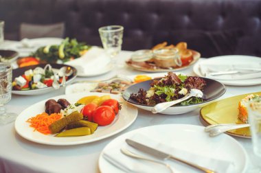 Tabaklar, salatalar, et tabakları ve mezeler ile şenlik masası.