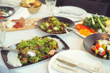 Tabaklar, salatalar, et tabakları ve mezeler ile şenlik masası.