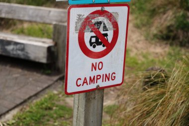 Doğal yol yasağı sembolünün yanında gece kalmayı yasaklıyor. Kırmızı beyaz.