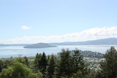 Sakin su, sonsuz yeşil yamaçların yakınındaki uzak toprakları sarar. Doğa manzarası.