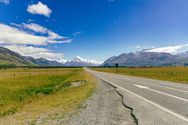 Açık kırsal yol, uzak tepelere, asfalt ok şeridi yolculuğuna götürür.