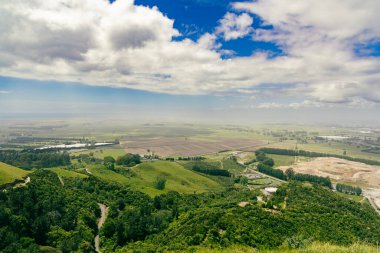Geniş kırsal bölgeler bulutlu gökyüzü tarım arazilerinin altındaki tarlaları gösteriyor.