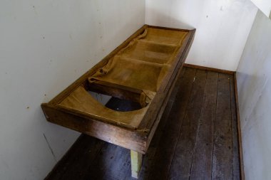 Dar köşedeki ahşap döşemenin içinde basit kırsal mobilyalar.