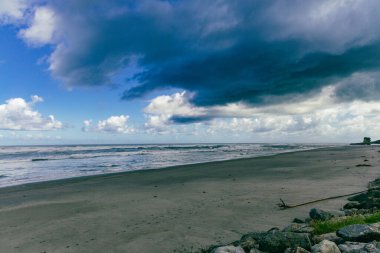 Karamsar kıyı dalgaları dramatik gökyüzü kumsal sahili kıyısı kumları altında