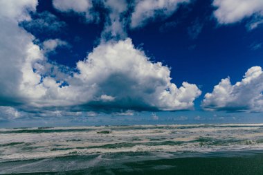Köpüklü dalgalar yükselen gökyüzünün altında dalgalanır fırtınalı deniz manzaralı dalgalar kıyılarda dalgalanır