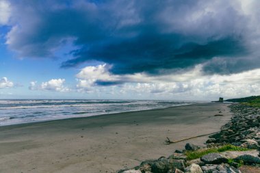 Issız sahil sahili kıyısı boyunca karanlık hava yaklaşıyor.