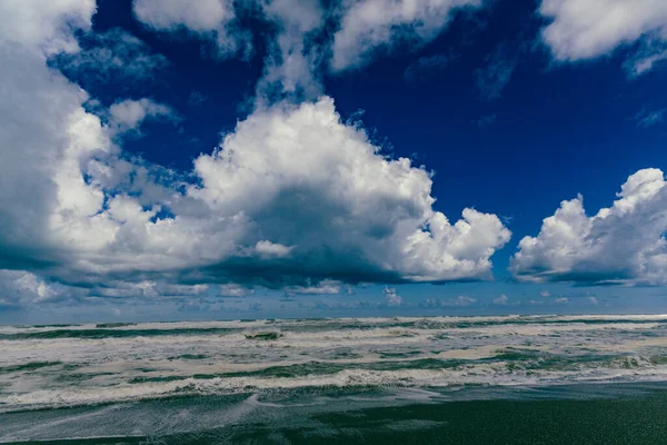 Köpüklü dalgalar yükselen gökyüzünün altında dalgalanır fırtınalı deniz manzaralı dalgalar kıyılarda dalgalanır
