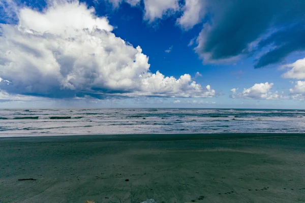 Karamsar kıyı dalgaları yüksek gökyüzü fırtınalı deniz suyu dalgaları altında gösteriyor.