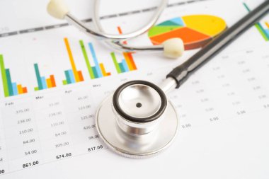 Çizelge ya da grafik kağıdı, Finansal, hesap, istatistik ve iş verileri medikal sağlık kavramı üzerine steteskop ve ABD doları banknotları.