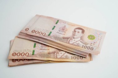 Asyalı kadın Tayland baht banknotlarını sayıyor ve elinde beyaz arka planda tek başına duruyor..