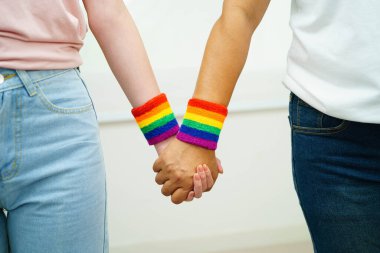 Gökkuşağı bilekliği takan Asyalı LGBT çifti..