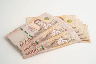 Asyalı kadın Tayland baht banknotlarını sayıyor ve elinde beyaz arka planda tek başına duruyor..