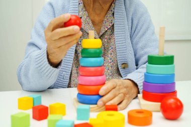 Asyalı yaşlı bir kadın, geliştirme oyunu oynuyor..