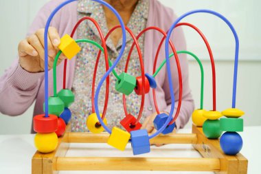 Asyalı yaşlı bir kadın, geliştirme oyunu oynuyor..