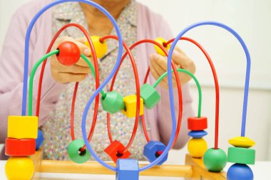 Asyalı yaşlı bir kadın, geliştirme oyunu oynuyor..