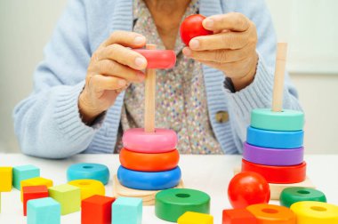 Asyalı yaşlı bir kadın, geliştirme oyunu oynuyor..