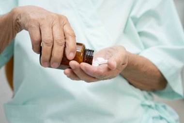 Asyalı yaşlı kadın elinde hap tutuyor, güçlü sağlıklı tıbbi konsept..