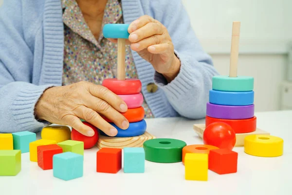 Asyalı yaşlı bir kadın, geliştirme oyunu oynuyor..