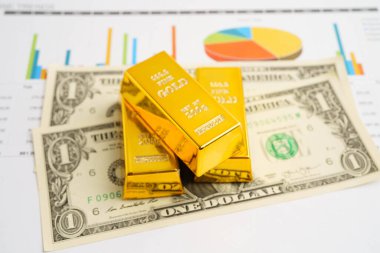 Gold bars on US dollar banknote money, finance trading investment business currency concept.