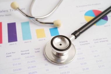 Çizelge ya da grafik kağıdı, Finansal, hesap, istatistik ve iş verileri medikal sağlık kavramı üzerine steteskop ve ABD doları banknotları.