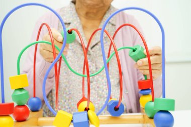 Asyalı yaşlı bir kadın, geliştirme oyunu oynuyor..