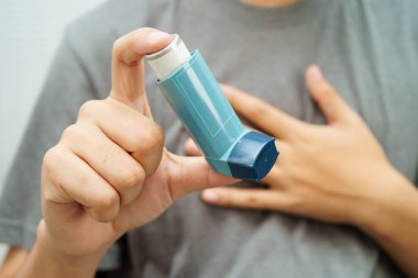 Astım ve kronik obstrüktif akciğer hastalığı KOAH, Asyalı genç ölçülü doz solunum cihazı kullanıyor..