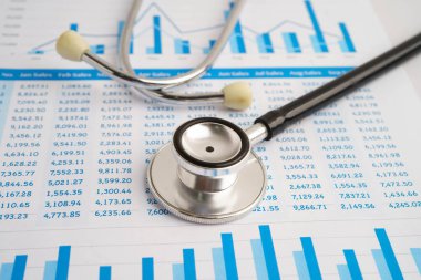 Çizelge ya da grafik kağıdı, Finansal, hesap, istatistik ve iş verileri medikal sağlık kavramı üzerine steteskop ve ABD doları banknotları.