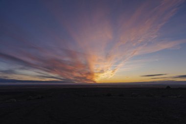 Nefes kesen bir günbatımı, yoğun turuncu ve mavi renklerle gökyüzünü aydınlatır..
