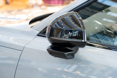 Modern bir aracın entegre kamera özelliği olan parlak siyah beyaz yan aynasına yakın çekim.