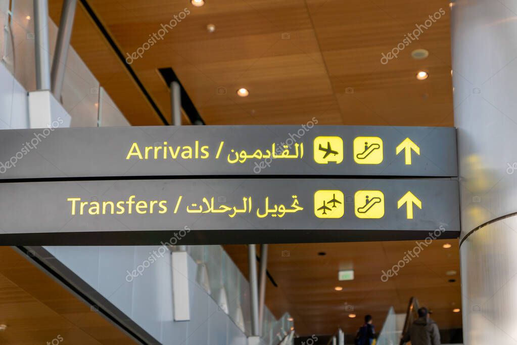 Airport arrival sign and transfer sign - international flight arrival information sign at airport in English and Arabic