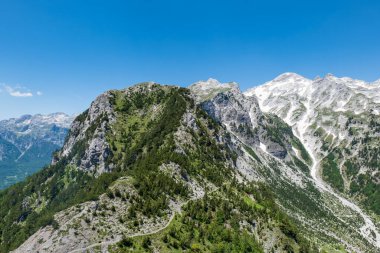 Arnavutluk Alpleri manzaralı. Arnavutluk 'ta Valbona ve Theth yürüyüş parkurlarından görülen lanetli dağlar, Arnavutluk Alplerinde popüler yürüyüş parkurları.