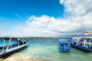 Lombok, Endonezya 'daki Gili adalarından biri olan Gili Trawangan' da turkuaz okyanuslu ve tekneli tropik kumlu bir sahil.