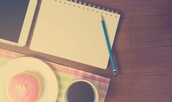 blank notebook page for writing in cafe. Cafe table top with writing equipment in vintage tone.