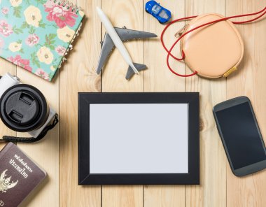 Boş seyahat resim çerçevesi ile ahşap masa üzerinde seyahat öğeler. Fotoğraf çerçevesi için tatil anıları. 