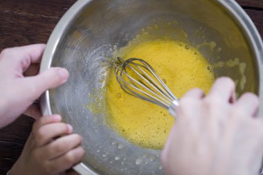 Anne öğretim çocuk Whisking ev yapımı dondurma çelik bir kase. 