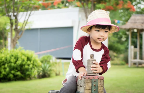 Asyalı çiftçi çocuk ahşap oyuncak kamyon şoförü üzerinde sürme. 