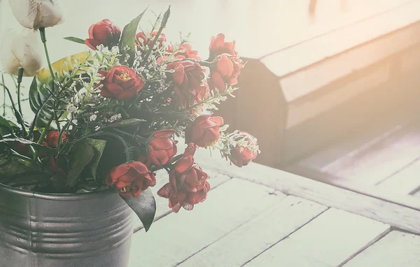 Balde de rosas em tom vintage com espaço de cópia. flor de tecido na mesa de madeira em tonificação vintage . — Fotografia de Stock